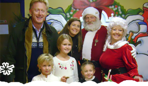 Family posing for a photo with Santa and Mrs. Claus