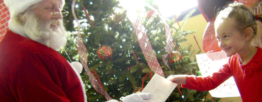 A child giving her letter to Santa Claus